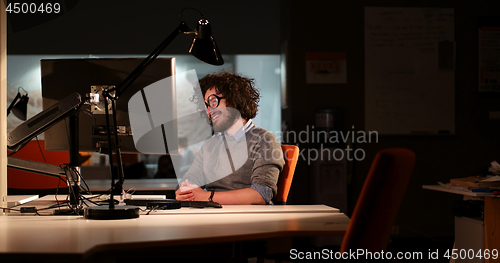 Image of man working on computer in dark office