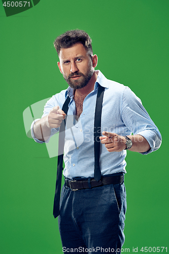 Image of The overbearing businessman point you and want you, half length closeup portrait on green background.