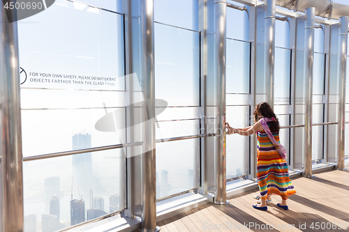 Image of Female tourists having fear of heigh at the top the observation deck of the highest building in the world,Burj Khalifa in Dubai, UAE.