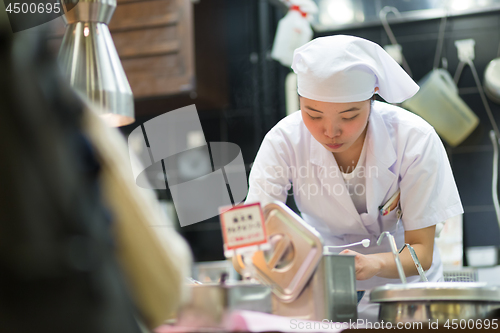 Image of Japanese Ramen chefs prepare a bowl of traditional home made ramen noodle for customers in Kyoto, Japan.