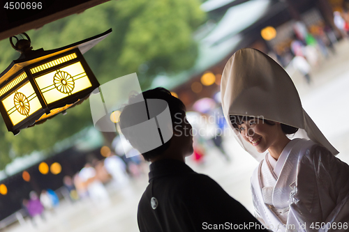 Image of Young happy groom and bride during japanese traditional wedding ceremony at Meiji-jingu shrine in Tokyo, Japan on November 23, 2013.