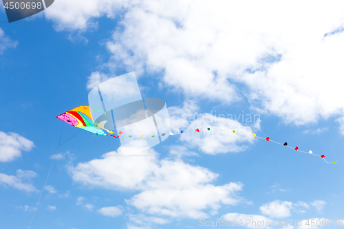 Image of Colorful kite on a blue sky with white clouds