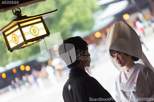 Image of Young happy groom and bride during japanese traditional wedding ceremony at Meiji-jingu shrine in Tokyo, Japan on November 23, 2013.