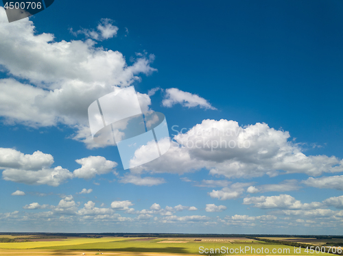 Image of Landscape with beautiful white clouds and fields on a background of blue sky in a sunny day. Aerial view frome drone,