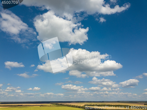 Image of Panoramic landscape with beautiful white clouds and fields on a background of blue sky in a sunny day. Aerial view frome drone,