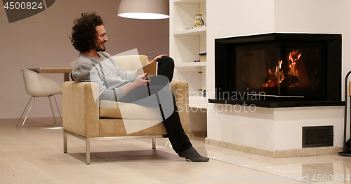 Image of young man at home reading book