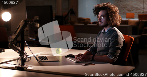 Image of man working on computer in dark office