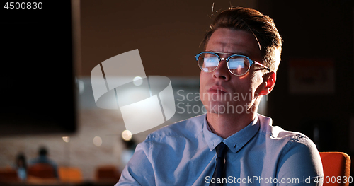 Image of man working on computer in dark office