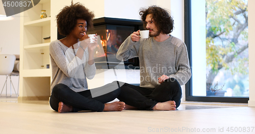 Image of multiethnic couple  in front of fireplace
