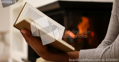 Image of black woman at home reading book