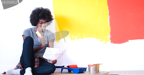 Image of black female painter sitting on floor