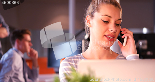 Image of woman using mobile phone in dark office