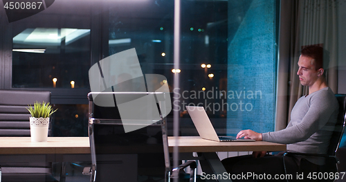 Image of man working on laptop in dark office