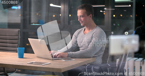 Image of man working on laptop in dark office