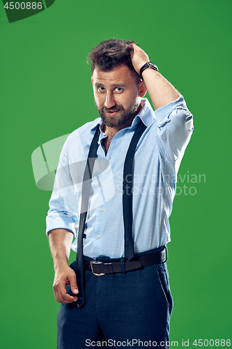 Image of Male beauty concept. Portrait of a fashionable young man with stylish haircut wearing trendy suit posing over green background.