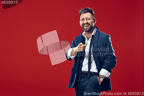 Image of The happy business man point you and want you, half length closeup portrait on red background.