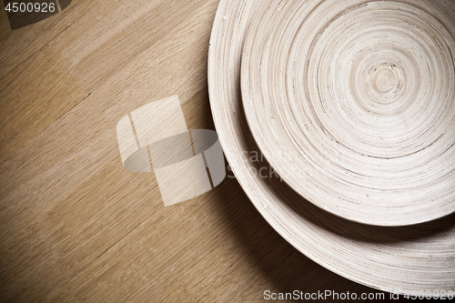 Image of Two bamboo bowls on wooden background.