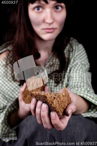 Image of Poor beggar woman with a piece of bread.