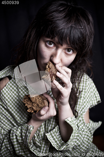 Image of Poor beggar woman with a piece of bread.