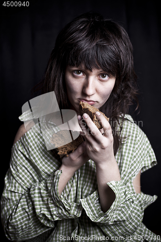 Image of Poor beggar woman with a piece of bread.