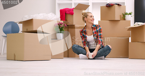 Image of woman with many cardboard boxes sitting on floor