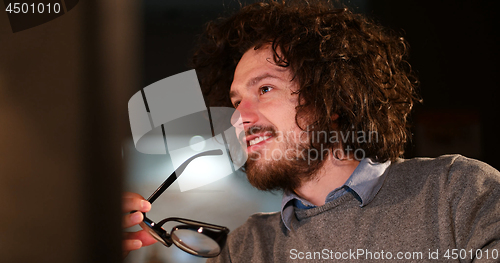 Image of man working on computer in dark office