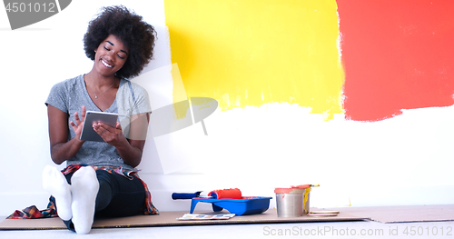 Image of black female painter sitting on floor