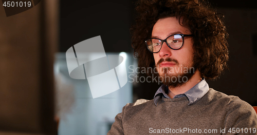 Image of man working on computer in dark office