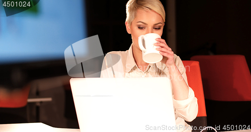 Image of woman working on laptop in night office