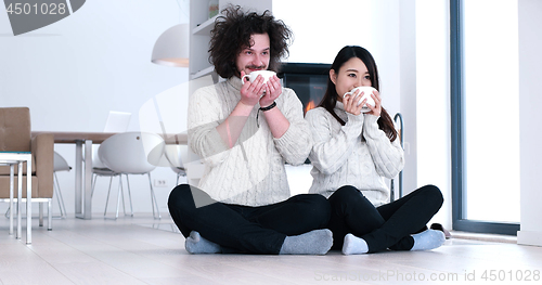 Image of multiethnic romantic couple  in front of fireplace