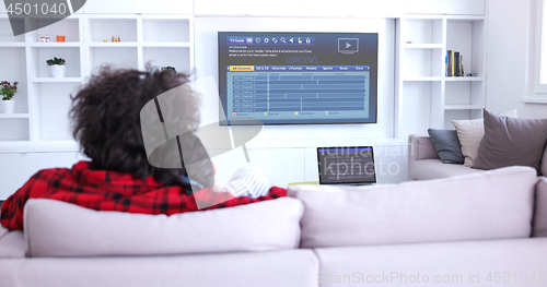 Image of Young couple on the sofa watching television