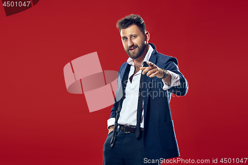 Image of The happy business man point you and want you, half length closeup portrait on red background.