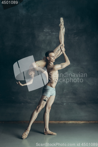 Image of The young modern ballet dancers posing on gray studio background