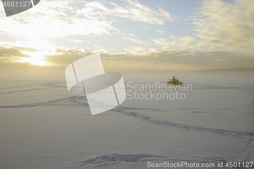 Image of snowmobile on a lake in a frosty day