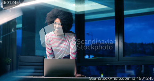 Image of black businesswoman using a laptop in night startup office