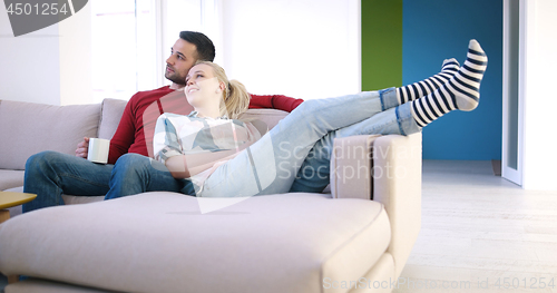 Image of Young couple on the sofa watching television