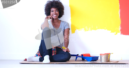 Image of black female painter sitting on floor