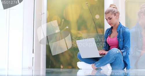 Image of young women using laptop computer on the floor