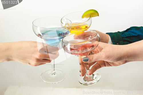 Image of The male and female hands with exotic cocktails