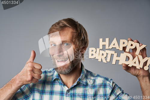 Image of Studio portrait of smiling mature man in checkered shirt