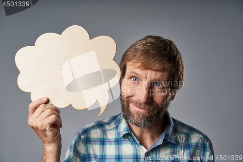 Image of Studio portrait of smiling mature man holding speech bubble