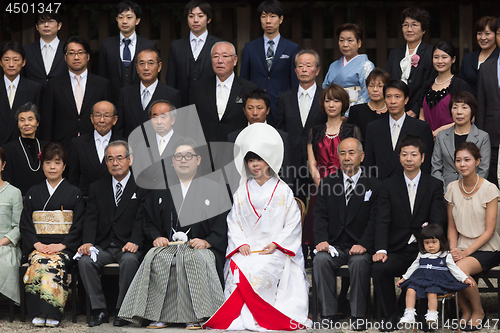Image of Official group photography ceremony of groom and bride,family and guests attending traditional japanese wedding at Meiji-jingu shrine inTokyo, Japan.
