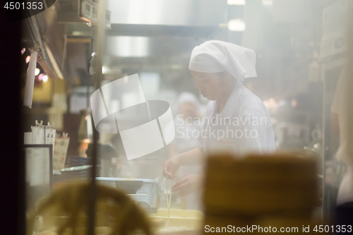 Image of Japanese Ramen chefs prepare a bowl of traditional home made ramen noodle for customers in Kyoto, Japan.
