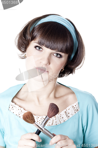 Image of  Pretty woman in blue dress with two make-up brushes