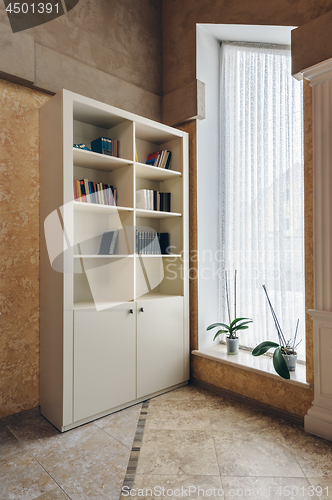 Image of bookcase near window in the big hall