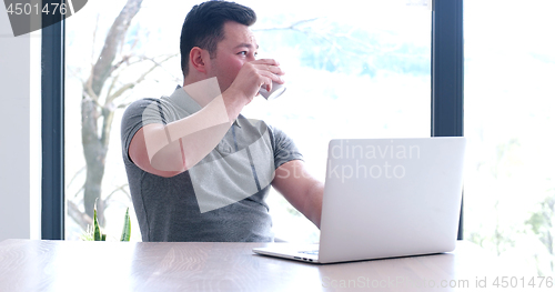 Image of businessman working using a laptop in startup office