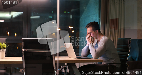 Image of man working on laptop in dark office