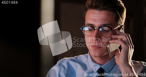 Image of man using mobile phone in dark office