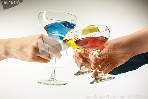 Image of The male and female hands with exotic cocktails