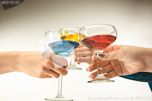 Image of The male and female hands with exotic cocktails